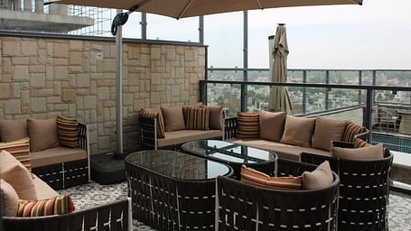 Rooftop lounge featuring sofas, pillows, and a patio offering stunning city views at BluSalzz Residence, Amritsar